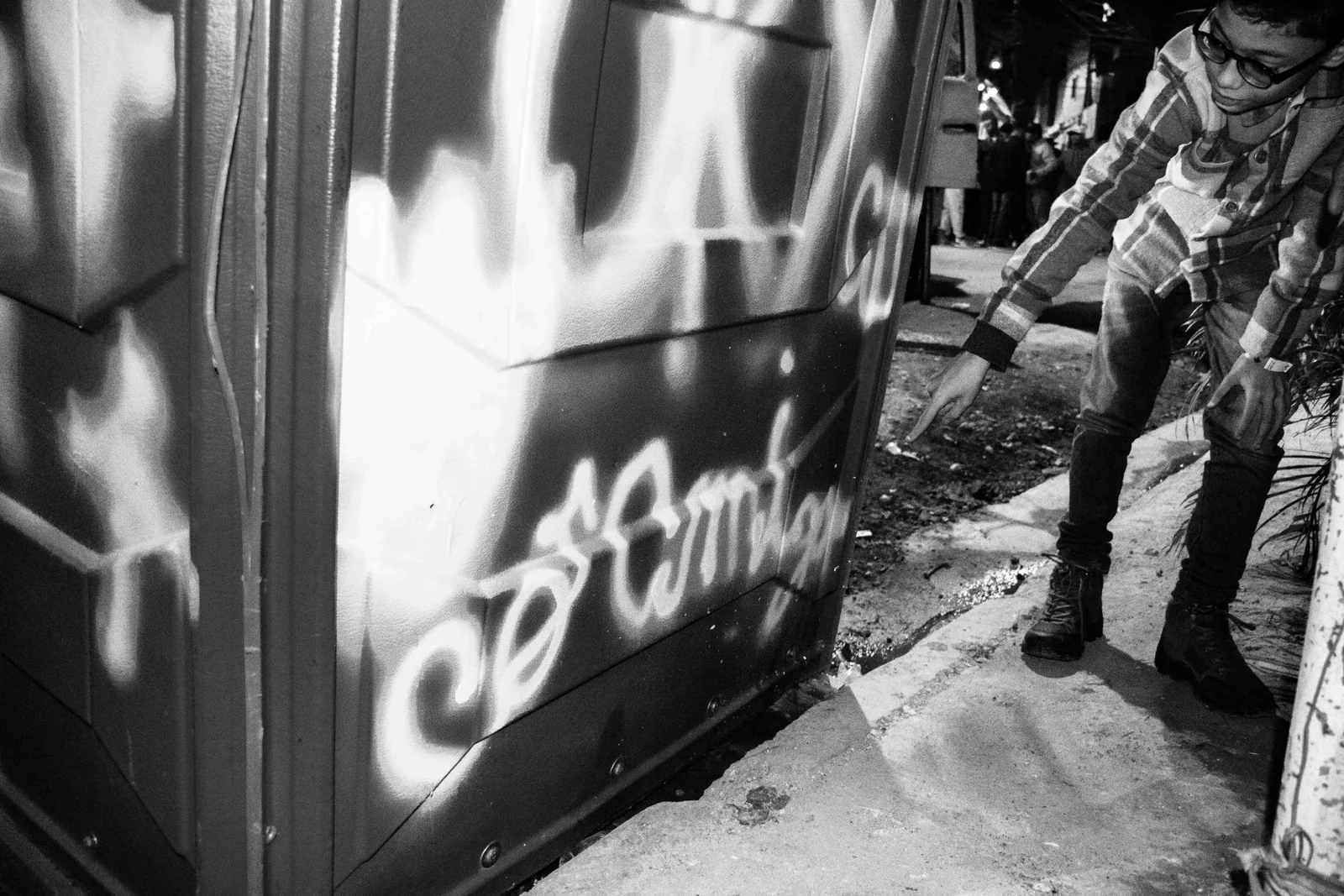 Pessoa diante de letras pintadas em superfície urbana