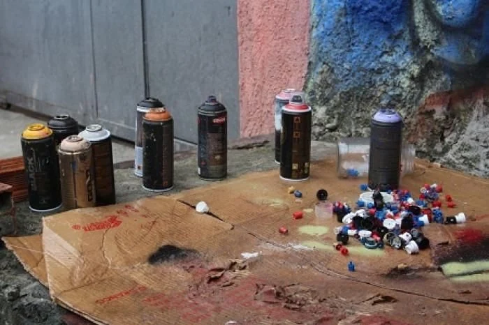 Latas de spray e materiais reunidos sobre uma mesa
