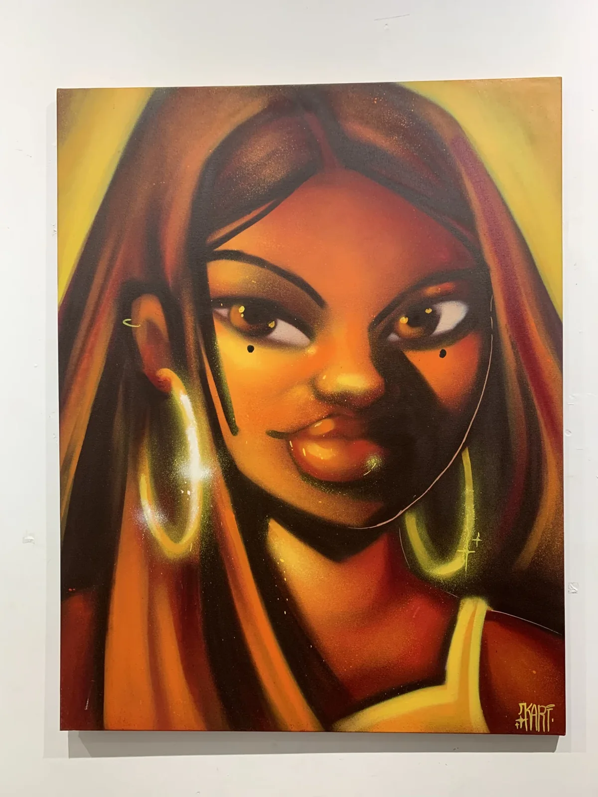 Obra sobre tela com figura feminina envolvida por tons laranja