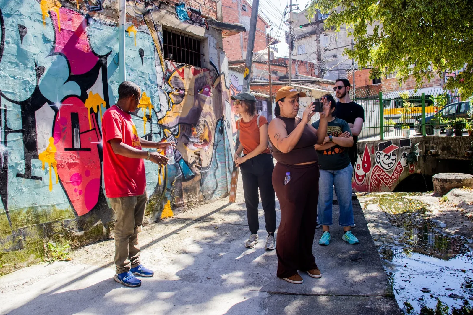 Visitantes param junto aos murais para observar e fotografar